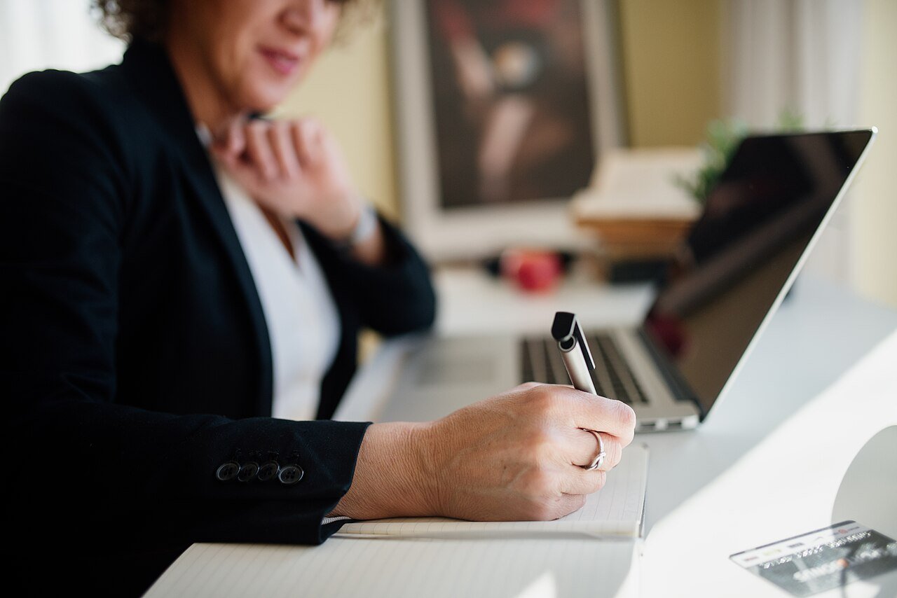 Business professional reviewing notes and documents at a modern office desk